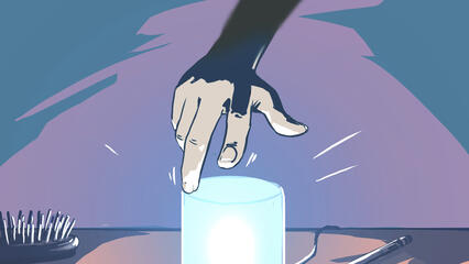 A hand reaches for a blue lamp